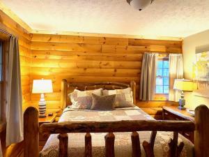 a bedroom with a bed in a room with wooden walls at Pine Creek - by The Chalets in South Bloomingville