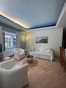 een woonkamer met twee witte banken en een tafel bij AurantiaSuites in Koroni