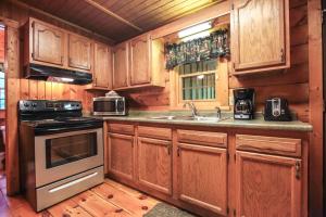 a kitchen with wooden cabinets and a stove top oven at Timber Ridge - by The Chalets in South Bloomingville