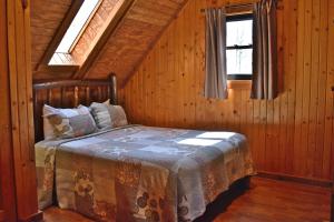 a bedroom with a bed in a wooden cabin at Sycamore - by The Chalets in South Bloomingville