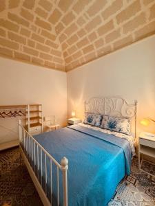 a bedroom with a bed with a blue comforter at Favignana in centro con terrazza in Favignana