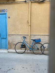 a bike parked next to a building with a blue door at Favignana in centro con terrazza in Favignana