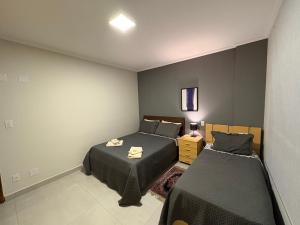 a bedroom with two beds in a room at Apartamento no centro de São Lourenço e a 750 metros do parque in São Lourenço