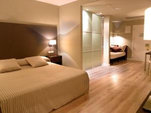 een slaapkamer met een bed en een kamer met een bank bij HG La Molina in La Molina