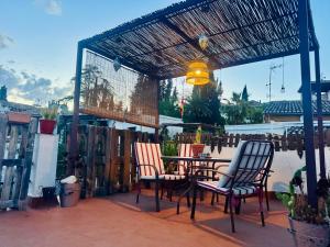 een terras met een tafel en stoelen onder een pergola bij Casa Albaicin 1 in Granada