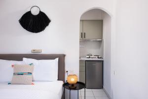 a bedroom with a bed and a table with a lamp at Acroterra - Easy Living in Alyki +118 photos