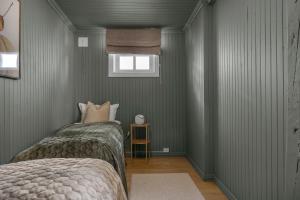 una camera da letto con pareti verdi e un letto con finestra di Stylish City Apartment With Mountain View a Tromsø