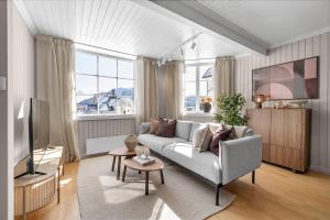 un soggiorno con un divano e una TV di Stylish City Apartment With Mountain View a Tromsø