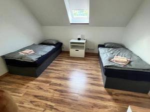 two beds in a small room with a table at Ubytování v Nalžovicích in Nalžovice