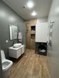 a bathroom with a toilet a sink and a washing machine at Дом с бассейном в Ереване in Aghk'ilisa