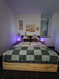 a bedroom with a black and white bed with purple lights at Zentrales City-Apartment mit Garage und Arbeitsplatz geeignet für Business und Familie in Duisburg