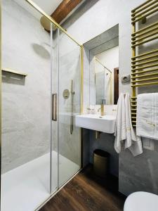 a bathroom with a glass shower and a sink at Prague Golden Age in Prague