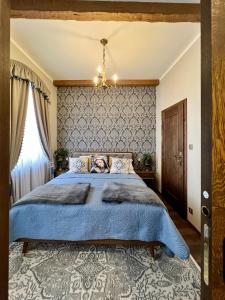 a bedroom with a blue bed and a chandelier at Prague Golden Age in Prague