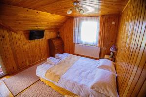 a bedroom with a large bed in a wooden room at Casa de Vacanta Hanes in Pianu de Sus