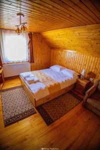 a bedroom with a bed in a wooden room at Casa de Vacanta Hanes in Pianu de Sus