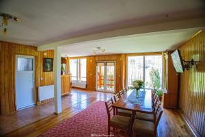 a dining room with a table and chairs in a room at Casa de Vacanță Haneș - Private Cabin - Orchard & Mountain Views - Transalpina & viaTransilvanica in Pianu de Sus