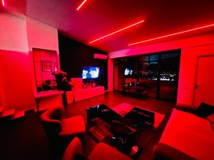 a living room with red lights and red chairs at SecretS Room in Baku