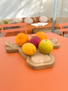 Un montón de fruta en un plato de madera sobre una mesa. en Tente Sancy, en Chambon-sur-Lac