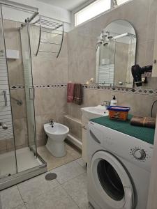 a bathroom with a washing machine and a shower at Studio with sea view near the beach in Playa de las Americas