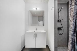 a white bathroom with a sink and a shower at Beautiful harbor view apartment in Hvide Sande +18 photos