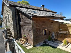 un grande edificio in legno con patio e tavolo di Maison de campagne atypique à Tence a Tence