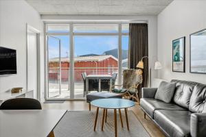 a living room with a couch and a table at Beautiful harbor view apartment in Hvide Sande
