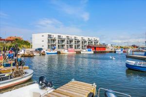 a group of boats docked in a harbor with a building at Beautiful harbor view apartment in Hvide Sande