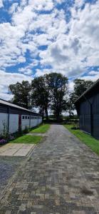 an empty road leading to a building with trees in the distance at Bed and Breakfast 't Klokhuis in Langedijke +10 photos