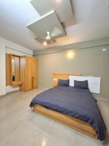 a bedroom with a bed with blue sheets and a ceiling at Oakhaven Apartments near Mico Layout in Bengaluru +29 photos