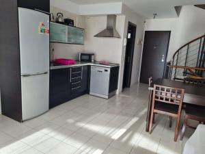 a kitchen with a refrigerator and a table and a chair at Sunset view duplex in Callao Salvaje
