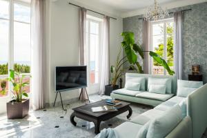 a living room with a couch and a tv at Villa Fantaisie in Menton