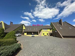 日托米尔Sava Dream的一栋建筑，停车场里停着一辆车