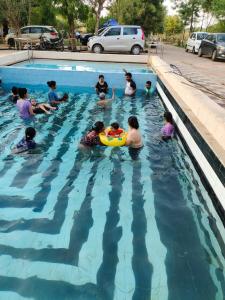 a group of people in a swimming pool at The Heaven - Farms & Resorts in Ānakhol