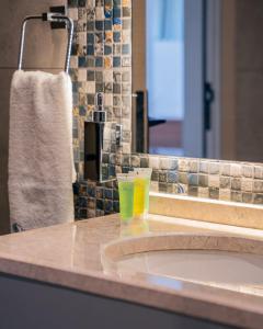 a bathroom counter with a sink with a glass on it at Las palmas resort in Sowayma