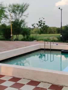 a swimming pool with blue water in a brick yard at The Heaven - Farms & Resorts in Ānakhol