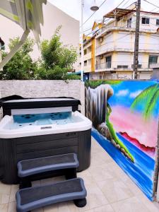 Un jacuzzi frente a una pared con un cuadro. en Soleil des îles, en Sainte-Anne