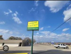 a sign in front of a parking lot with a truck at Saint Roberts Town and Village Motel in Saint Robert