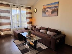 a living room with a brown couch and a table at Hermann's Sea View Apartment - Bendita Mare in Varna City +17 photos