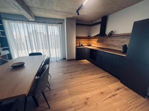 a kitchen with a long wooden table and a table and chairs at Апартамент САМИ in Dobrich