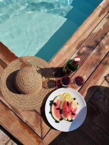 un chapeau et une assiette de fruits au bord d'une piscine dans l'établissement Milas-Bodrum Özel Havuzlu Triplex Villa, à Milas