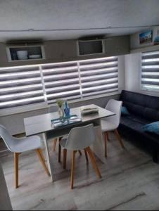 a living room with a table and chairs and a couch at Mobil home pour 5 personnes La mouette in Berck-sur-Mer