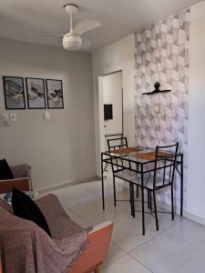 un salon avec une table, des chaises et un canapé dans l'établissement Loft Ymará Arraial, à Arraial do Cabo