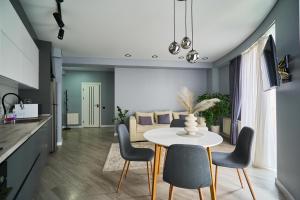 Una cocina y una sala de estar con mesa y sillas. en Full-Equipped 1BR in Center by Torro Mall, en Chişinău