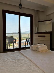 - une chambre avec un lit et une grande fenêtre avec vue dans l'établissement Milas-Bodrum Özel Havuzlu Triplex Villa, à Milas 57 autres photos