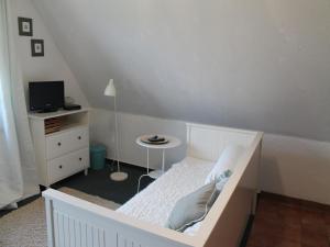a bedroom with a white bed and a table at Studio in Dargun mit Pool am Kummerower See in Barlin