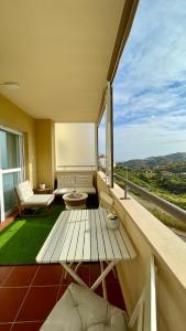 a balcony with a table and a large window at Luna home in Torrox