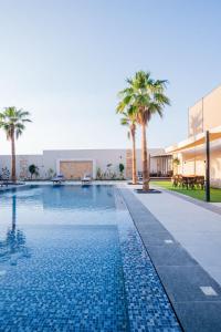 a swimming pool with palm trees next to a building at Las palmas resort in Sowayma +27 photos