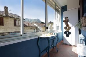 a blue room with a table in front of a window at In the Historic Village - Riva Lago 10 in Carate Urio