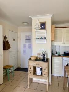 una cucina con tavolo e bollitore per il tè. di Appartement rez-de-chaussée entre dunes et ocean a Lacanau-Océan