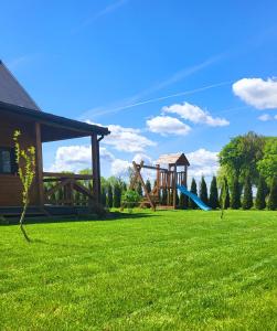 a playground with a slide in a green field at Domek nad Nieliszem in Nielisz +15 photos